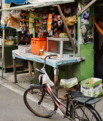 Warung kecil di pinggir jalan dengan jajanan renceng tergantung